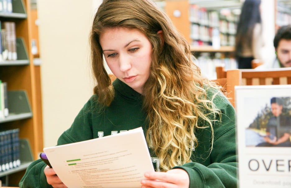 A student looks over a sheet in the UT Dallas library.